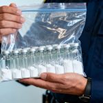 CBP officer holding intercepted weight loss peptides.